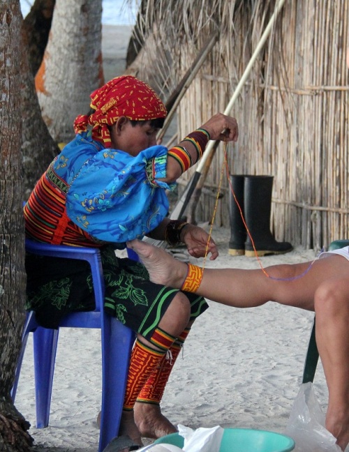 Kuna woman dressing up a tourist's ankle in their typical beads